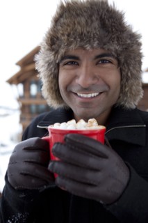 Smiling man drinking hot chocolate outdoors