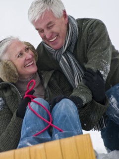Caucasian couple sledding in snow together