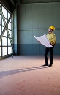 Caucasian architect reviewing blueprints