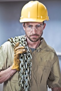 Caucasian worker in hard-hat holding chains