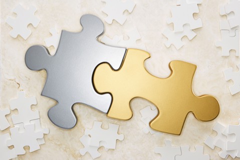 Close up of gold and silver puzzle pieces
