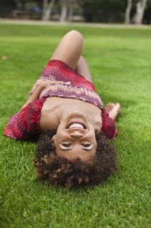 Smiling mixed race woman laying in grass