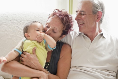 Couple holding baby on sofa