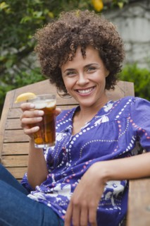 Mixed race woman drinking iced tea