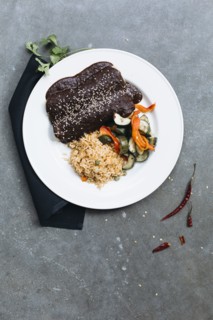 Plate of enchiladas with vegetables and rice