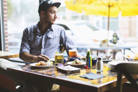 Caucasian man eating tacos in restaurant