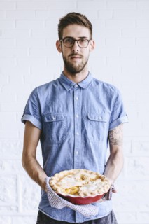 Caucasian man holding peach pie