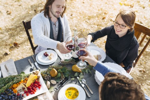 Caucasian friends toasting with wine at outdoor table