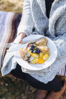 Caucasian woman holding plate of food outdoors