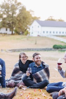Friends drinking wine in rural field