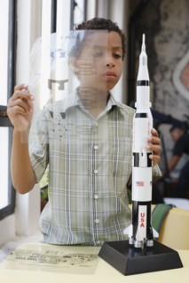 Mixed race boy building model rocket