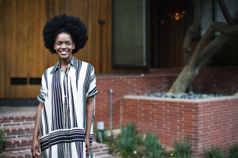 African American woman standing outside house