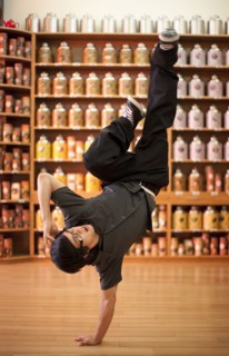Mixed race man doing handstand in shop