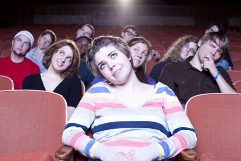 Caucasian woman watching movie in theater