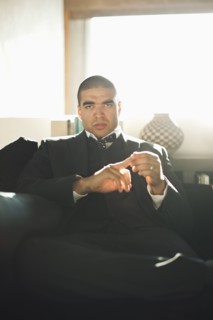 Serious mixed race businessman sitting in chair