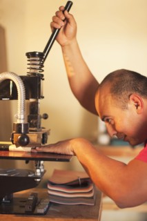 Hispanic man operating book-binding machine