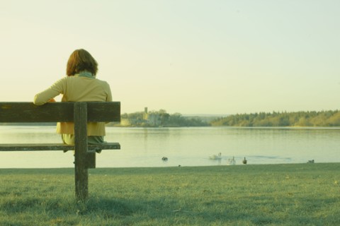 Caucasian teenage girl sitting on park bench