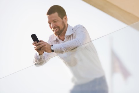 Caucasian businessman text messaging on cell phone