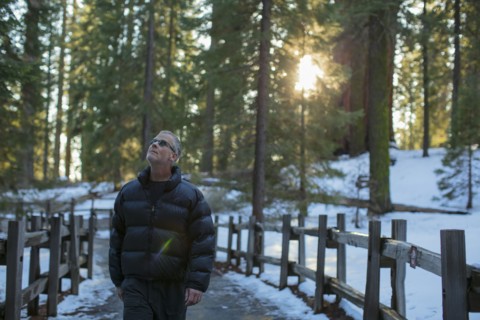 Caucasian man walking in snowy forest