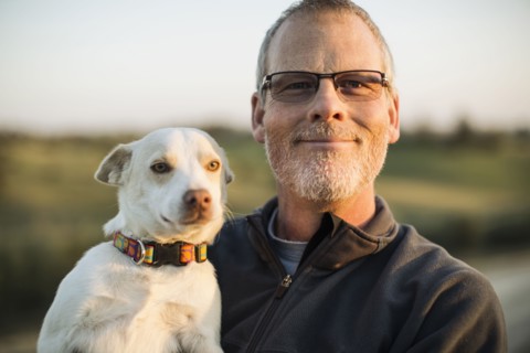 Caucasian man holding dog outdoors