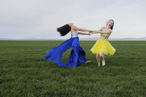 Teenage girls wearing gown in rural field