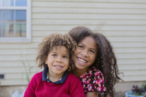 Pacific Islander brother and sister hugging outdoors