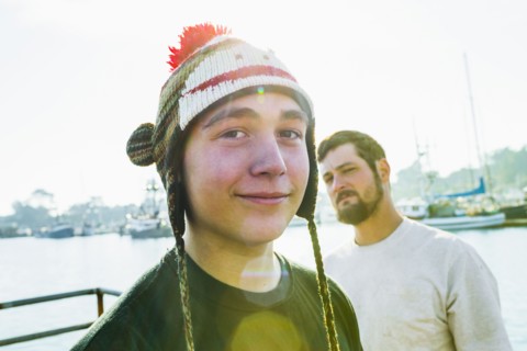 Caucasian boy wearing knitted cap in harbor