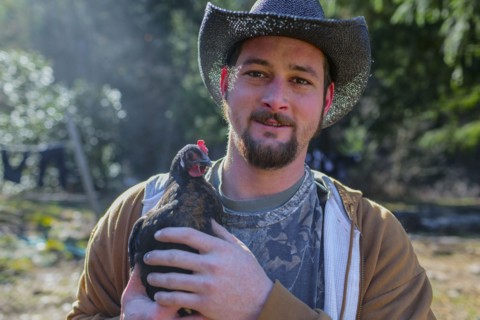 Caucasian farmer holding chicken