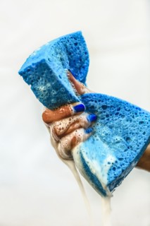 Chinese girl squeezing soapy sponge