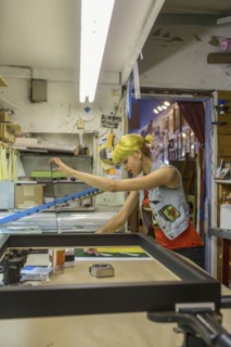 Caucasian artist working in screen print workshop