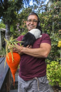Mixed race man carrying rabbit and knitted carrot
