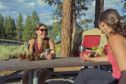 Caucasian women drinking wine at campsite