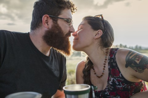 Caucasian couple kissing at picnic table