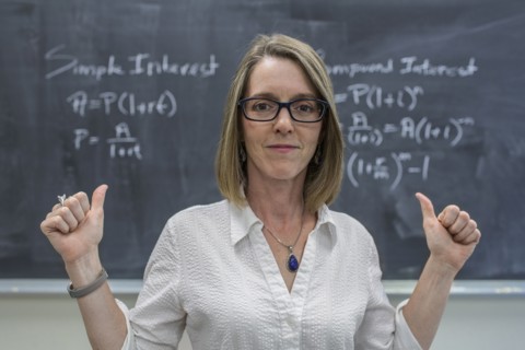 Caucasian teacher cheering at chalkboard