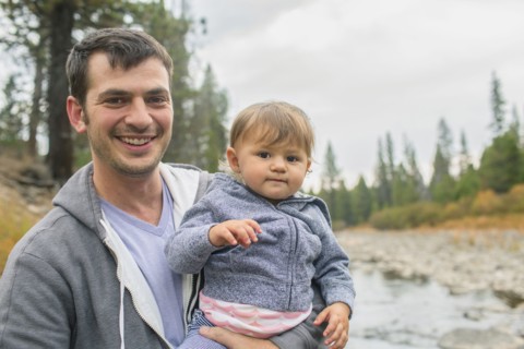 Father carrying daughter at river