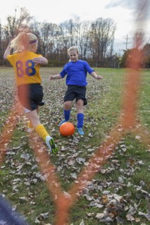 Caucasian girls playing soccer in field
