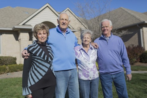 Older Caucasian friends smiling in yard