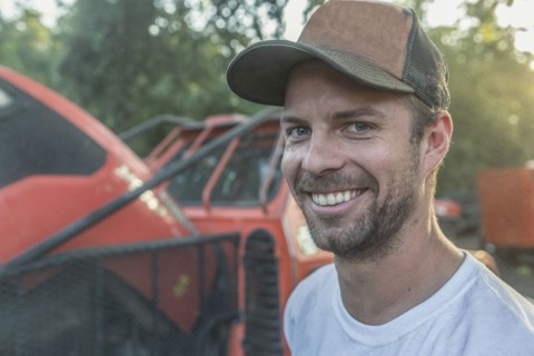 Caucasian man posing near tractor