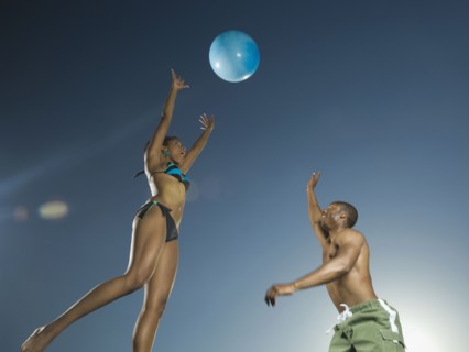 African American couple playing with beach ball