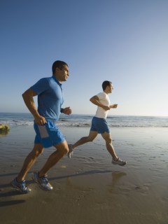 Hispanic men running at beach
