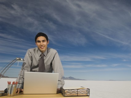 Hispanic businessman at desk on salt flats