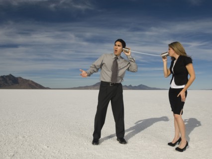 Hispanic businesspeople talking on can and string telephone