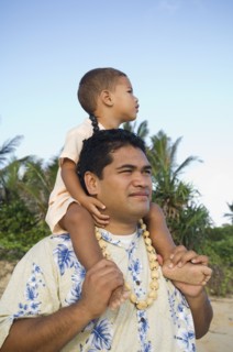 Pacific Islander father with son on shoulders at beach