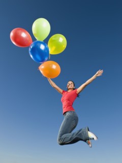 Native American holding balloons in mid-air