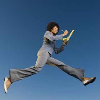 African businesswoman writing on legal pad in mid-air