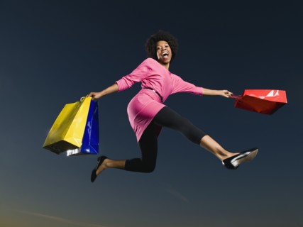 African woman holding shopping bags in mid-air