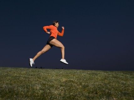Mixed race woman running on grass
