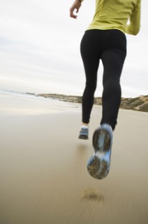 Hispanic woman running on beach