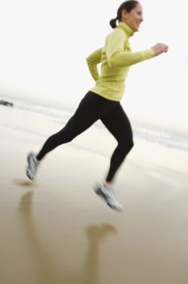 Hispanic woman running on beach