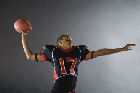Mixed race quarterback throwing football